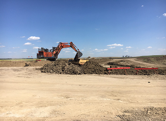 loader digging up dirt on construction site